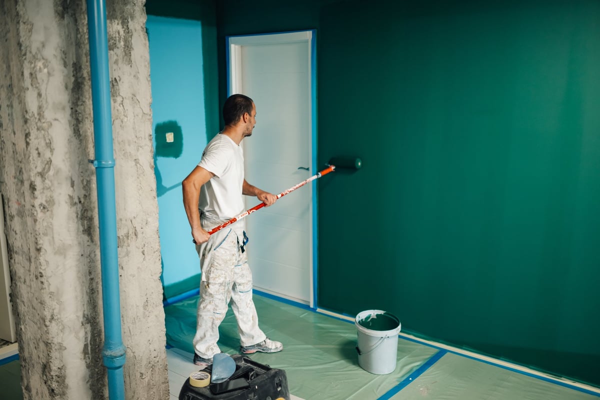 Professional painter applying paint on wall