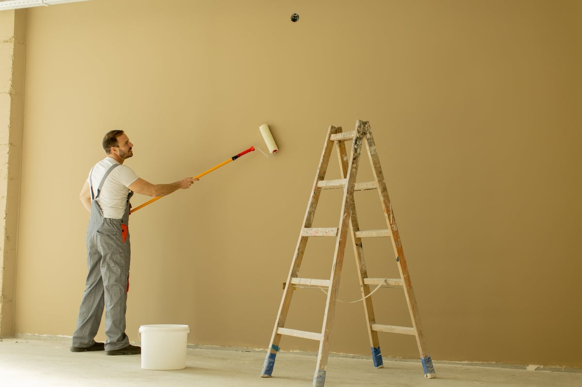 Painter applying paint on wall